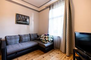 a living room with a couch and a television at Jurnieku nams in Liepāja
