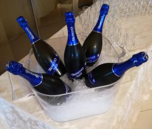 vier flessen wijn in een emmer op een tafel bij Hotel Lady Mary in Milano Marittima