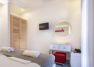 a bedroom with a bed and a mirror and a desk at Eva Mare Hotel & Suites - Adults only in Agia Pelagia