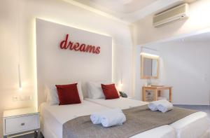 a bedroom with two beds with towels on them at Eva Mare Hotel & Suites - Adults only in Agia Pelagia