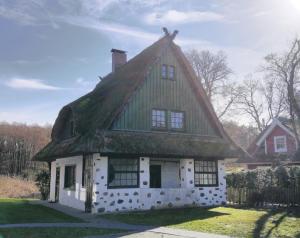 an old house with a grass roof at Darßer Strandgut - Haus Butzek in Ahrenshoop