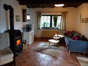 a living room with a couch and a fireplace at Darßer Strandgut - Haus Butzek in Ahrenshoop