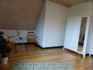 a living room with a white cabinet and a table at Darßer Strandgut - Haus Butzek in Ahrenshoop