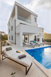 穆泰爾的住宿－Luxury Apartment La Mer，一座白色的房子,前面设有一个游泳池