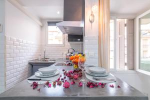 una cocina con una mesa con flores y copas de vino en Beau studio à 50m de la plage, en Niza