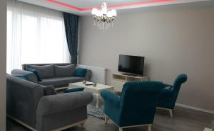 a living room with a couch and chairs and a tv at Fursan Apart My Doğa in Trabzon