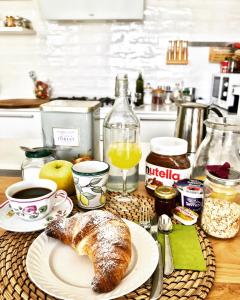 uma mesa com um prato de pão e um copo de sumo de laranja em Casa Maddy em Capri