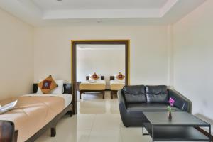 a living room with a couch and a chair at Boonme Heritage in Phitsanulok