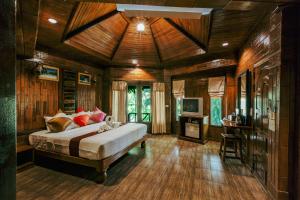 1 dormitorio con 1 cama en una habitación con paredes de madera en Phu Pha Aonang Resort & Spa, en Ao Nang Beach