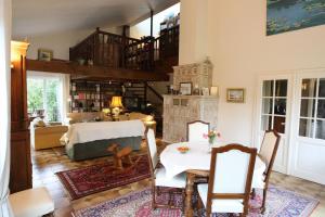 a living room with a table and a fireplace at Les Chambres de La Maxe in La Maxe