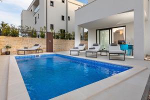 Luxury Apartment La Mer في مورتير: مسبح وكراسي ومنزل