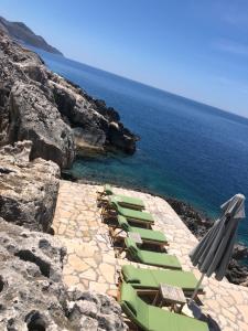 a group of chairs and umbrellas next to the ocean at Mandalina Suites in Kaş