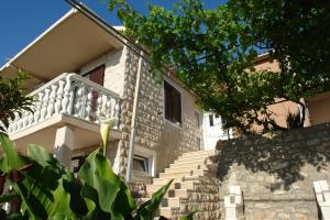 a house with stairs leading up to a balcony at R&B Apartments in Budva
