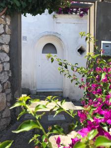 una porta bianca con fiori viola davanti di Casa Maddy a Capri