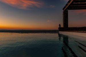 a pool of water with the sunset in the background at KEA'S VILLA in Otziás