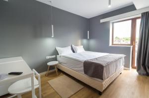 a bedroom with a bed and a desk and a window at Horeum Boutique Hotel in Sibiu