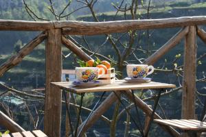 deux tasses de café sur une table en bois avec des fruits dans l'établissement Casa Sclavo, à Tramonti