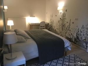 1 dormitorio con 1 cama y 1 mesa con lámpara en La Billebaude, en Mulsans