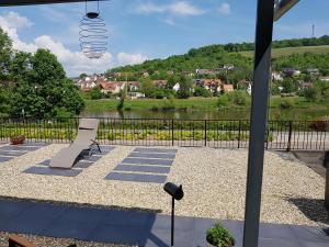 a patio with a bench and a view of a river at Ferienwohnung Eichelgasse Wertheim in Wertheim