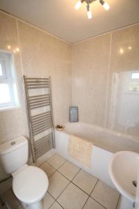 uma casa de banho com um WC, uma banheira e um lavatório. em Arle Farmhouse em Tobermory