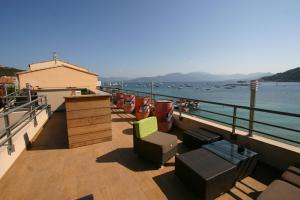 een balkon met stoelen en uitzicht op het water bij HOTEL CAMPOMORO in Campomoro