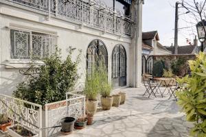 a patio with potted plants and a balcony at Les Chambres Lune in Saint-Aignan