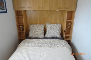 a bed with two pillows in a small room at St Pierre La Mer, VUE SUR MER, Quartier calme, T2 in Fleury