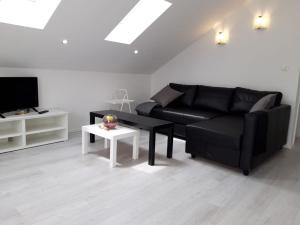 a living room with a black couch and a table at Cambi 11 in Kaštela