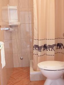 a bathroom with a toilet and a shower curtain at Holiday S&M in Lopar