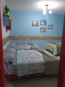 a bedroom with a bed and a blue wall at Pousada Vó Nita in Penha