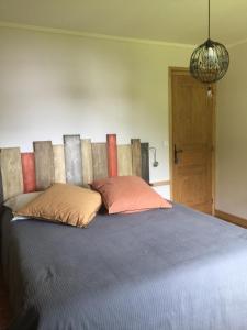 a bedroom with a large bed with two pillows at Chambres d'Hôtes Les Pierres Taillées in Thénésol