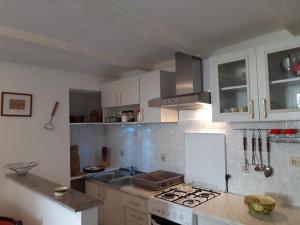a kitchen with white cabinets and a stove top oven at Holiday house Jasna in island center in Silba