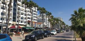 a city street with cars parked on the side of the road at Marina's Rooms in Larnaca