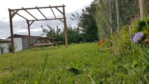 a wooden picnic table in a field of grass at Our relaxing holiday home in Mosteiros