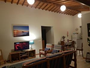 a living room with a flat screen tv on a wall at Our relaxing holiday home in Mosteiros