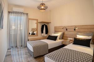 una camera d'albergo con due letti e uno specchio di Plakias Family Apartment a Plakiás
