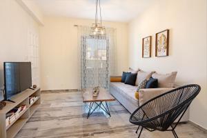 a living room with a couch and a tv at Plakias Family Apartment in Plakias