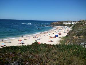 un grupo de personas en una playa cerca del océano en Al Casa Paquito, en Almograve