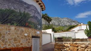 a view of a house with a stone wall at Apartamentos Montgò in Denia