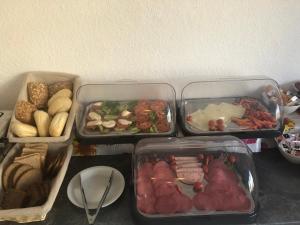 three trays of food on a table with food at Hotel Oldesloer Hof in Bad Oldesloe