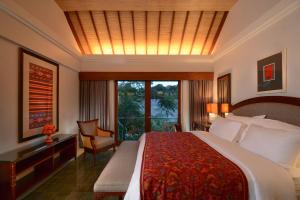 a hotel room with a large bed and a window at Kama Village by Nakula in Sanur