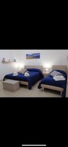 2 Betten in einem Schlafzimmer mit blauer Bettwäsche in der Unterkunft La Strettola in Neapel