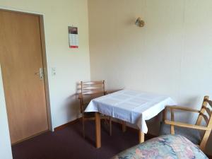 ein kleines Zimmer mit einem Tisch, Stühlen und einer Tür in der Unterkunft Ferienwohnung Harms 2 in Hitzacker