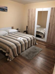 a bedroom with a large bed and a mirror at Old SALONA in Solin