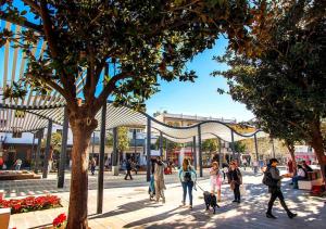 a group of people walking a dog on a sidewalk at New Central Studio Torremolinos in Torremolinos