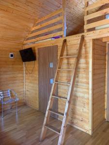 a wooden room with a ladder and a tv at Domki Międzyzdroje in Międzyzdroje