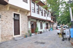 安塔利亚贡特公寓的一名男子站在一栋建筑物前