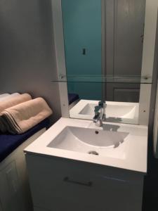 een badkamer met een witte wastafel en een spiegel bij Gîte Les Feuilles de Chêne in Carpentras