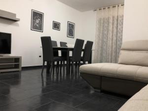- une salle à manger avec une table, des chaises et un canapé dans l'établissement Apulia Tourist Salento, à Gemini