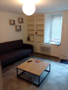 a living room with a couch and a coffee table at La maison des remparts in Lectoure